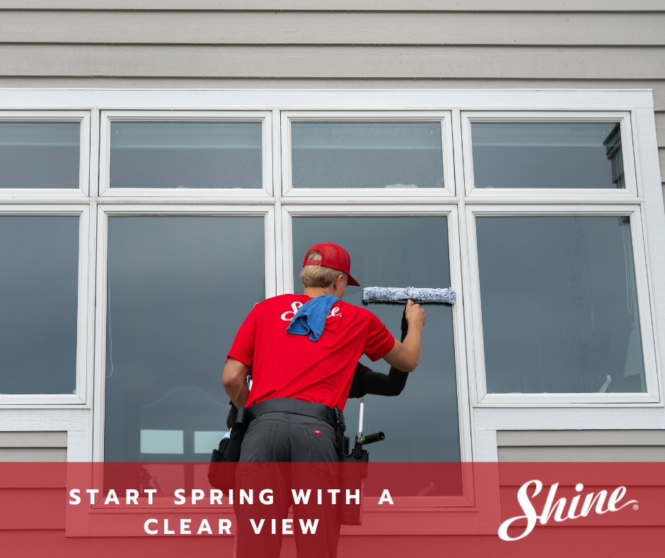 Shine technician cleaning a large residential window with professional tools